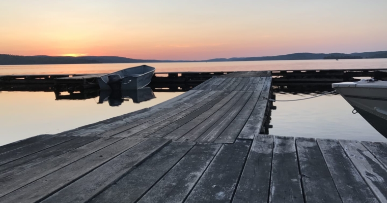 Boat docks on Bark Lake at sunset