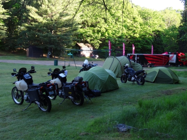 Several motorcycles and tents in a campground