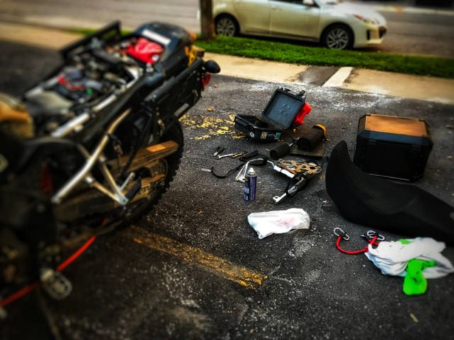 a photo of a Suzuki motorcycle being repaired in a parking lot