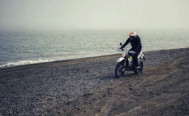 A photo of a Husqvarna enduro motorcycle on the beach at Martins Head, NB