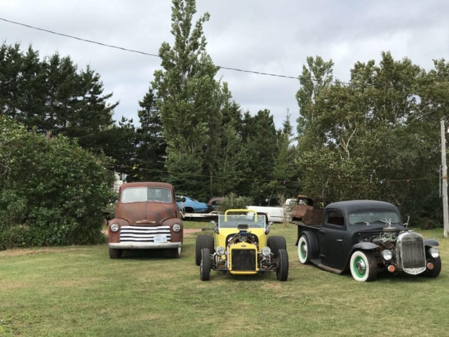 Some hot rods on a lawn near Christopher Cross PEI