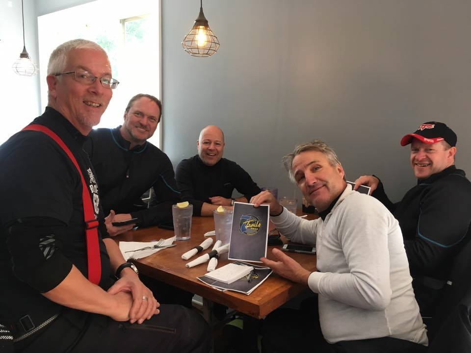 a photo of several men sitting at a restaurant table 