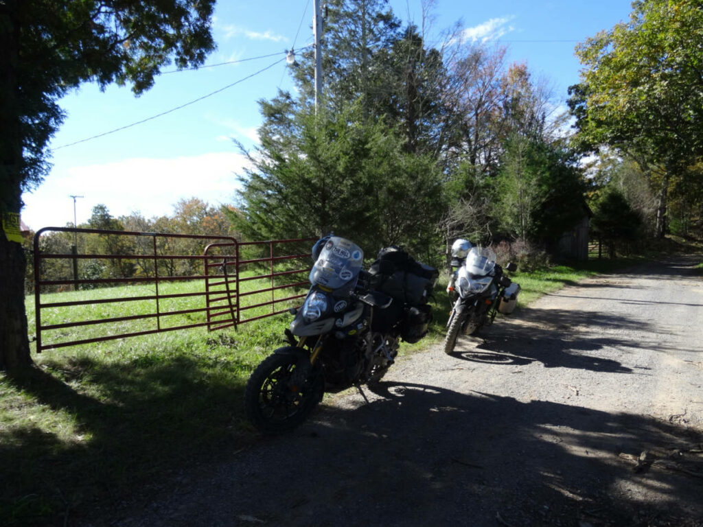 2 adventure style motorcycles on a forested gravel road