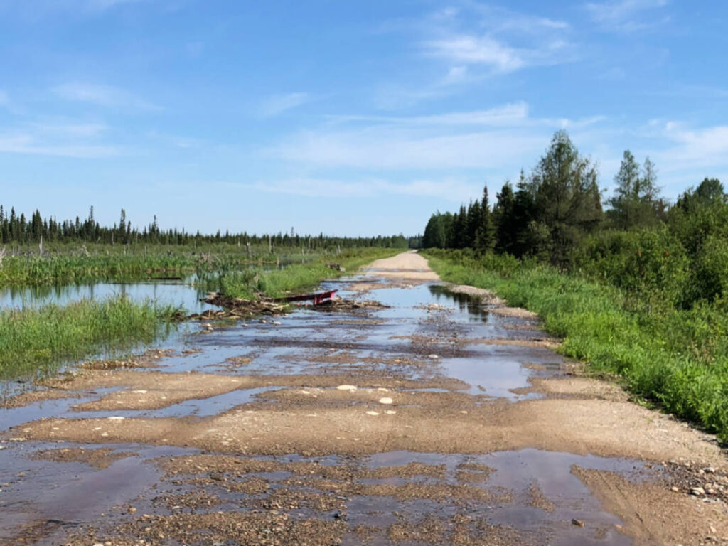 a photo of a gravel road covered in water 