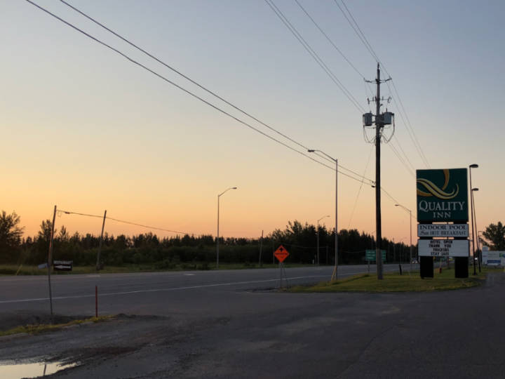 A sunset photo of a Quality Inn hotel sign